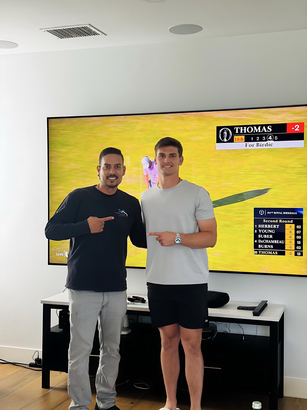 Tony with LA Rams Quarterback Ty Simpson in front of a wall-mounted TV installation